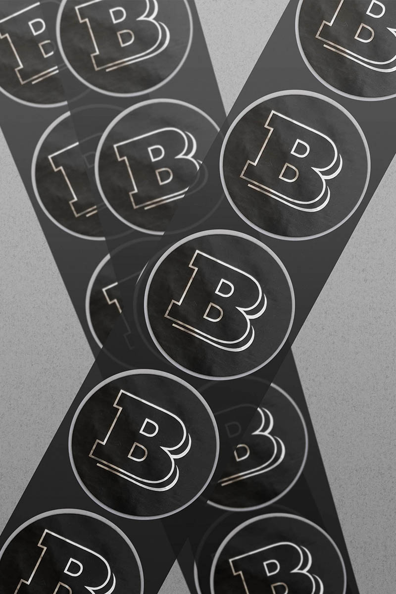 Schwarz-silberne, runde Aufkleber mit dem Buchstaben B übereinandergereiht.
