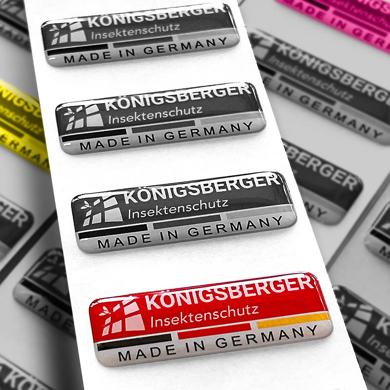 Aufkleber der Marke Königsberger in schwarzweiß, gelb und magenta.