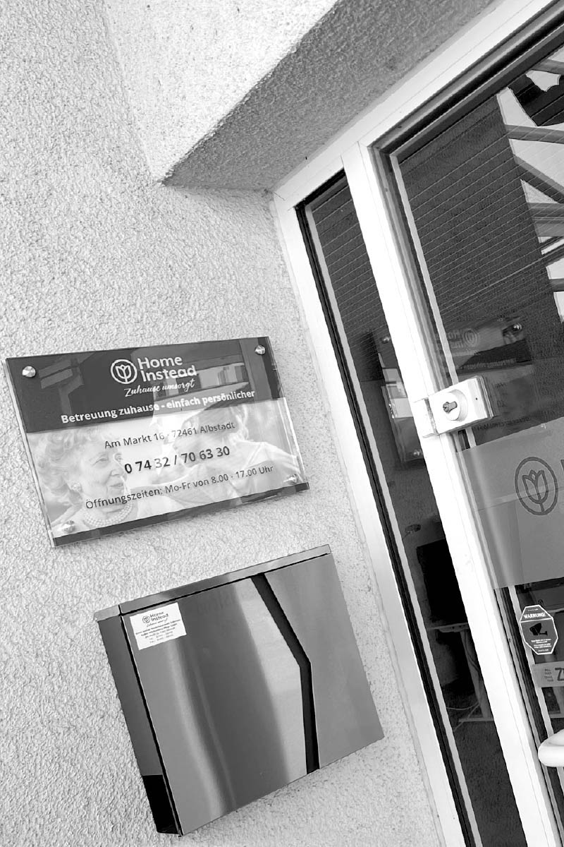 Beschilderung von Home Instead an einer Eingangstür.