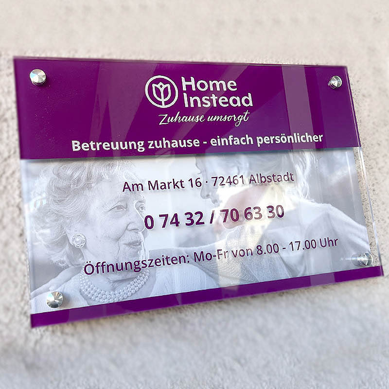 Hauswand Beschilderung von Home Instead an Fassade am Straßenrand