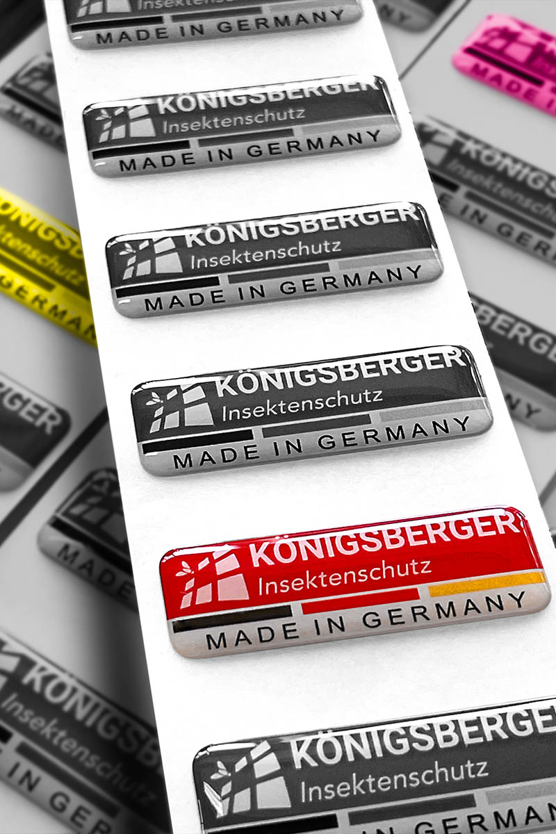 Etiketten der Marke Königsbereger in schwarzweiß, gelb und magenta.