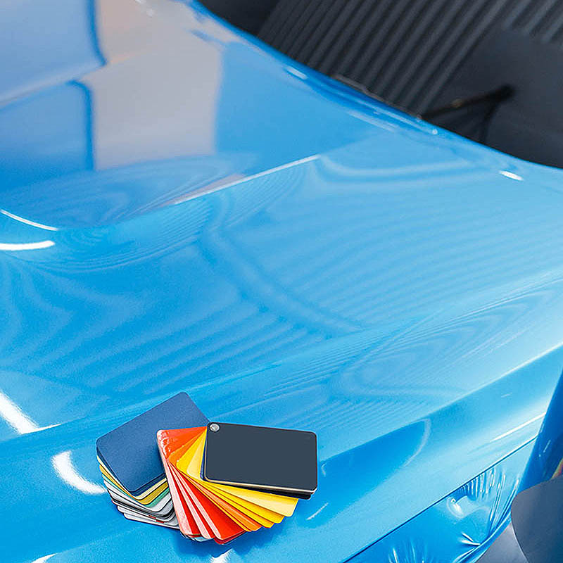 Man sieht eine Hand, die mit speziellem Werkzeug die Folierung glättet.