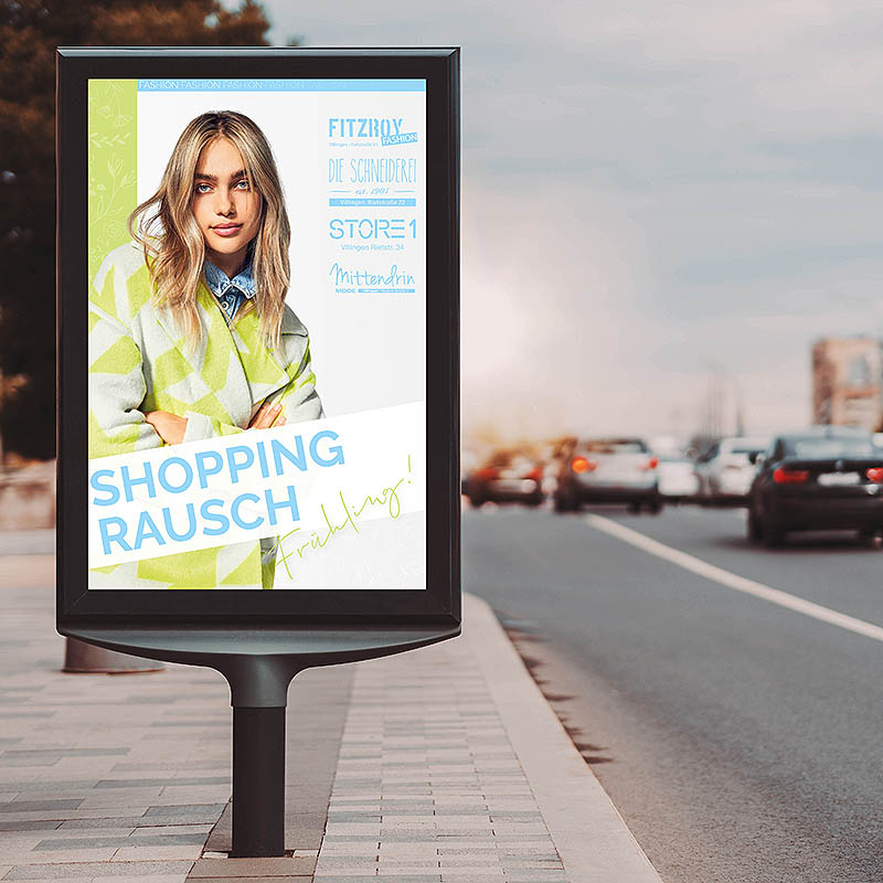 Plakatwerbung an befahrener Straße mit Modeplakat und Sonnenuntergang im Hintergrund.